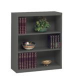 A gray metal bookshelf with three shelves. The top shelf holds a decorative plant; the middle has a bowl with a floral pattern; and the bottom displays a gold decorative bowl. Each shelf is lined with dark red, gold-embossed books.