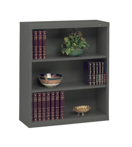 A gray metal bookshelf with three shelves. The top shelf holds a decorative plant; the middle has a bowl with a floral pattern; and the bottom displays a gold decorative bowl. Each shelf is lined with dark red, gold-embossed books.