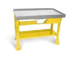 A yellow and gray workbench with a raised tray surface, a small drawer underneath, and a lower shelf. The structure has sturdy legs, suitable for industrial or workshop use.