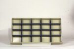 A beige and black empty storage organizer with 18 square compartments is placed against a plain white background.