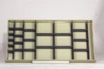 A beige wooden shelf with multiple compartments, designed for organizing items. The shelf has evenly spaced vertical and horizontal dividers of varying sizes, creating a grid pattern against a plain white background.