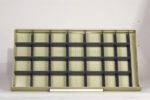 Empty beige shelving unit with multiple sections and black horizontal dividers, set against a plain background.