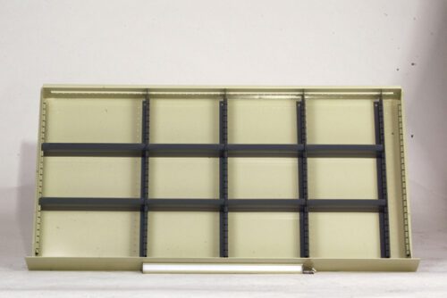 A beige metal shelving unit with a grid-like structure and several black horizontal dividers, standing against a plain white background. A fluorescent light tube sits at the base of the unit.