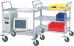 A metal utility cart on wheels with three shelves. The bottom shelf holds a computer tower and monitor. The top and middle shelves have plastic bins in yellow, blue, and red, containing small items.