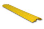 The Yellow TCT Small Cable Cover 39.25x5.25x0.845 features a textured surface and a channel size of 1.5x0.5, designed to protect cables and reduce tripping hazards with its narrow shape and bottom grooves for cable accommodation.