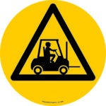 The yellow warning sign, featuring a black forklift silhouette in a triangle, warns of forklift traffic. It serves a similar purpose to the MH-USA Floor Graphic Markers Without Text (16.93 in diameter), which designate forklift truck areas.