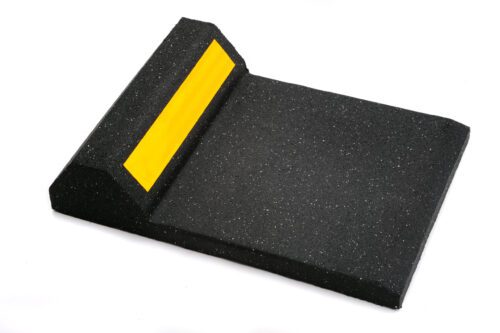 The TCT Garage Stop w/ Reflective Stripe is a black rubber curb with a textured, sloped surface and raised edge, featuring a bright yellow reflective stripe on top for visibility to prevent vehicles from rolling past the parking area.