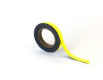 On a white surface, an MH-USA Magnetic Easy-Wipe Strip in yellow (H.0.79 in. x W3.94 in.) stands upright, with a portion unrolled and curling slightly at the end.