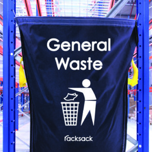 A blue MH-USA Racksack - General Waste fabric bag hangs on metal shelves, featuring an icon of a person discarding trash into a bin and the brand name Racksack elegantly at the bottom.