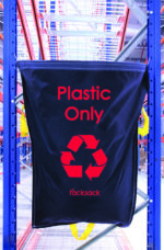 A black MH-USA Racksack - Plastic Only bag, featuring a red recycling symbol, hangs on a blue metal rack in an industrial space. The Racksack brand is prominently displayed with steel shelves and a ceiling grid in the backdrop.
