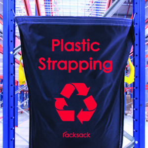 A blue MH-USA Racksack - Plastic Strapping, featuring red text and a recycling symbol, hangs neatly on a metal rack in a warehouse.