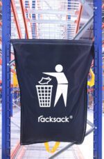 A blue MH-USA Racksack Symbol Only - General Waste hangs in the industrial shelving area, featuring a white icon of a person disposing of waste into a bin, symbolizing efficient general waste management among the sturdy metal beams and shelving units.