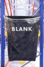 A large black plastic container labeled BLANK hangs on a sturdy blue MH-USA Racksack Clear - Blank in a busy warehouse, surrounded by metal shelves and industrial structures for an authentic and efficient storage setting.