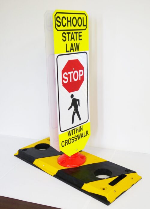 The TCT Flexible Post Crosswalk System features a yellow and black sign with School State Law - Stop Within Crosswalk, including a red stop sign graphic over a walking figure, mounted on a robust black and yellow base.
