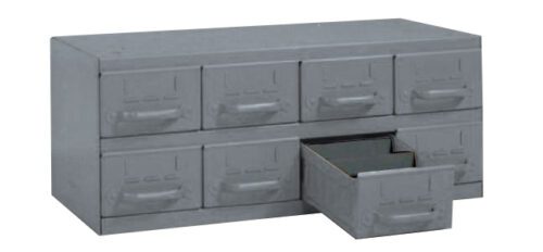 A gray metal organizer with eight small drawers. One drawer is partially open, revealing a small compartment. The organizer has a simple, industrial design.