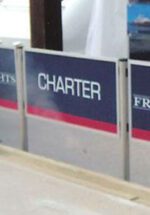 A CHARTER sign in white text on blue with red and silver borders, crafted with the Visiontron Designer Series Panel System, stands prominently in a row of similar signs.