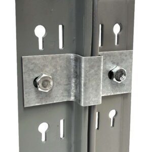 Close-up of a metal bracket connecting two vertical beams with bolts. The beams have multiple keyhole-shaped slots. The bracket is secured with two hexagonal bolts, and a cable runs through the middle between the beams.