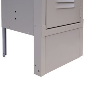 Close-up of the bottom section of a beige metal locker, featuring vents on the door and rivets on the frame. The locker is elevated on metal legs, partially visible in the image.