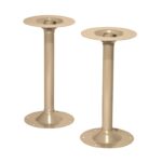 Two beige metal support columns with circular bases and top plates. Each column has multiple holes for mounting, suitable for securing structures like tables or shelves. The design is simple and industrial.