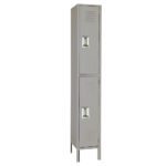 A tall, narrow gray metal locker with two compartments, each with a handle and ventilation slots. The locker stands upright on four legs.