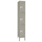 A tall, narrow, gray metal locker with three stacked compartments, each featuring a vented door and a handle. The locker stands on four short legs.