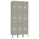 A gray metal locker unit with three columns and three rows, totaling nine compartments. Each locker has a silver handle and ventilation slots. The unit stands on raised legs.