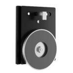 The Visiontron Magnetic Wall Mounting Plate for WM412 Series showcases a black metal bracket with a large gray pulley wheel. It features two bolt holes for secure mounting and a small hook above the wheel, with its sleek design highlighted shown at a slight angle.