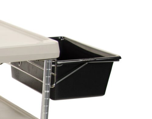 4u5vsh791jcubuwx6708spns02tjmx8h.jpg Close-up of a black Metro MYUB2 myCart Series Utility Bin and Holder for MY2030 attached to a white metal shelf with a wire frame. A corner of a white tabletop is visible above the bin, set against a plain white background.