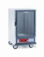 The Metro C515-HXFC-UA C5 1 Series, a half-height stainless steel holding cabinet with universal wire slides and a transparent door, operates at 220-240V. It features control knobs and a digital display on the bottom front panel, plus four wheels for easy mobility.