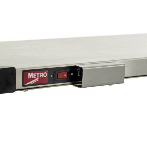 Close-up of a metal platform featuring a control panel with a red switch and a MAX dial. The METRO logo on the left suggests its part of the Metro HS-THERMCOVER for Super Erecta Hot Shelves and Metro2Go Hot Stations.