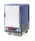 The blue Metro C535-MXFS-U-BUA C5 3 Series insulated food transport cabinet has a full-length solid door, universal wire slides, wheels, and three control knobs. Operating at 220-240V with moisture heat functionality, it is set against a white background.