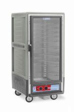 The Metro C537-HFC-U-GY is a 3/4 height insulated holding cabinet that operates at 120V and features a full-length clear door revealing interior shelves. It includes Universal Wire Slides, a bottom control panel with red and blue dials, and four wheels for easy mobility.