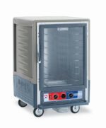 The Metro C535-MFC-4-GY C5 3 Series Heated Holding/Proofing Cabinet features a full-length clear door, fixed wire slides, and control knobs at the bottom. Mounted on wheels for easy mobility, this 1/2 height cabinet ensures efficient food storage with its innovative design.