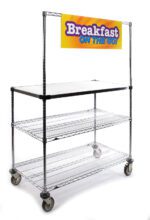 The Metro GG2436 Breakfast Cart, 24 x 36, has two wire shelves and a solid top with a Breakfast on the Go! sign. Featuring four wheels and a vibrant yellow banner with purple text, this versatile cart is perfect for your serving needs.