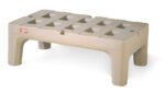 The Metro HP2236PD Bow-Tie Dunnage Rack, measuring 22 x 36, is a sturdy beige plastic rack with a grid-like surface and short legs. Its designed for practicality in any space and features a small red and white logo on one side for easy identification.