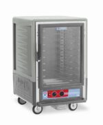The Metro C535-HLFC-U-GYA C5 3 Series Insulated Holding Cabinet features a full-length clear door, universal wire slides, and a control panel with dials and gauges at the bottom. This mobile cabinet runs on 120V, 60Hz, and 1440W, has a sleek gray exterior, and is on wheels for easy mobility.