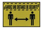 The Justrite Mat features a yellow sign with black borders and diagonal lines, displaying two stick figures separated by an arrow. The French text GARDEZ UNE DISTANCE DE SÉCURITÉ reminds all to KEEP A SAFE DISTANCE.