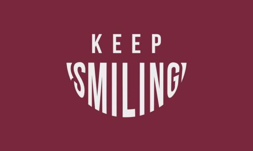 KEEP SMILING text appears on a maroon background, with SMILING creatively styled as a smile, echoing the vibrant appeal of the Justrite Mat at 195 Keep Smiling 3X5 Rd.