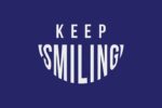 A text graphic on a dark blue background reads KEEP SMILING, with SMILING designed in an elongated, curved style that forms a smile, inspired by the playful aesthetics of the Justrite Mat, 195 Keep Smiling 4X6 Bu collection.