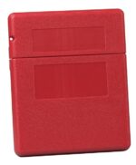 Red plastic case with a design similar to the Justrite Doc Box, Med Fliptop. It features two rectangular indentations on the front, a slightly smaller embossed top section as a lid, and a textured surface. A small hole in the top left corner allows for secure hanging.