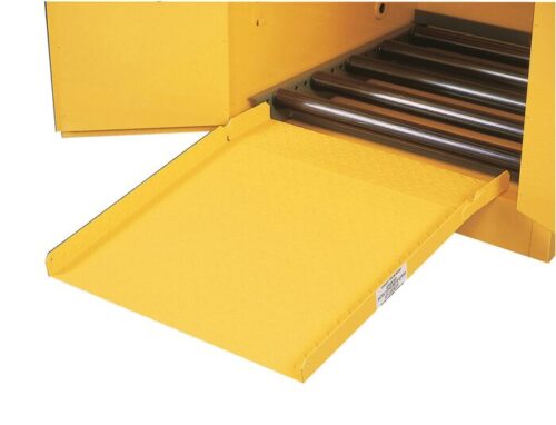 A close-up of a yellow industrial machine shows a Justrite Drum Ramp, F/All Drum Cabinets extending outward. The ramps textured surface complements the machine’s interior lined with metal rollers for efficient operation.