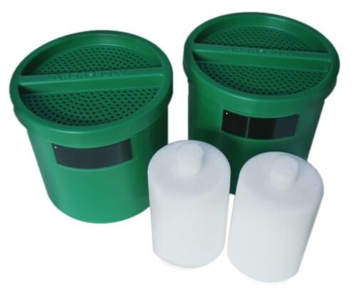 Two green, round containers with perforated lids are labeled Justrite Filter, Hieff Crb/Clscr, 2Pk, Aer, accompanied by two cylindrical white items, creating a functional or collectible set for enthusiasts of Hieff Crb/Clscr design.