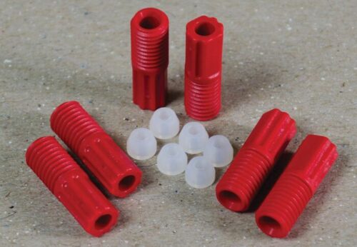 Red, threaded plastic anchors and small white caps from the Justrite 3.0 Mm Tubing Connector Set are neatly arranged on a textured surface with six red anchors and eight white caps evenly spaced.