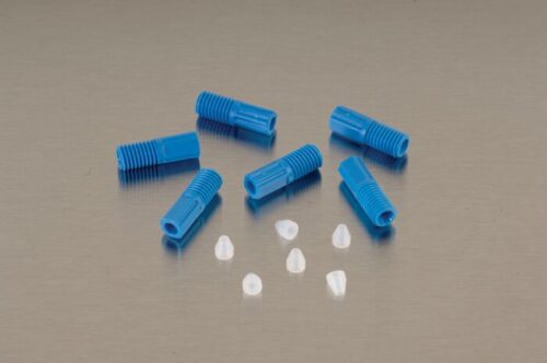 Seven blue, cylindrical Justrite Fitting F/Hrd Wall Tube 1/16OD pieces and six small, white cone-shaped objects are scattered on a flat beige surface. The blue pieces, resembling connectors or caps, have ridged sections.