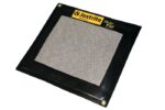 A Justrite Pad with a mesh center, black in color, features a yellow Justrite Drip Pad label in the corner and meets the Drip Standard 21X23.