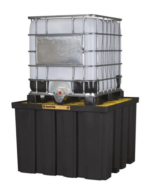 A large white industrial container with a metal frame sits on a Justrite Pallet, Ibc Indoor, Ecopoly black spill containment pallet, featuring a visible nozzle at the bottom.