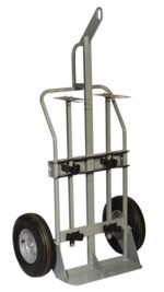 The Justrite Gcyl Ht,2Cyl,Hr,Fpt,16 hand truck has large rubber wheels and a sturdy frame with handle grips. Its vertical back and bottom nose plate assist lifting, while straps keep items secure during transport.