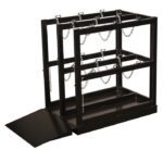 The Justrite Gcyl Fklft Pllt,6Cyl,Br,Rmp is a sleek black metal cylinder storage rack with three vertical compartments secured by chains and an inclined ramp for easy gas cylinder access and organization.