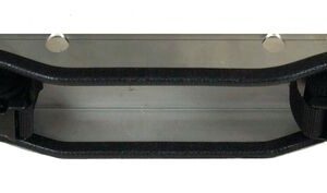 The Justrite Gcyl Supbrkt, Wl, 2Cyl, Ss features a wavy metal design with two black straps and buckles. It is adorned with evenly spaced circular holes along its length on a white background.