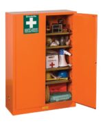 A Justrite Cabinet, Emergcy 65X43 Orng stands open, showcasing safety gear: first aid kit, emergency blanket, megaphone, radio, and hard hats. The door prominently displays a green sign with a white cross.
